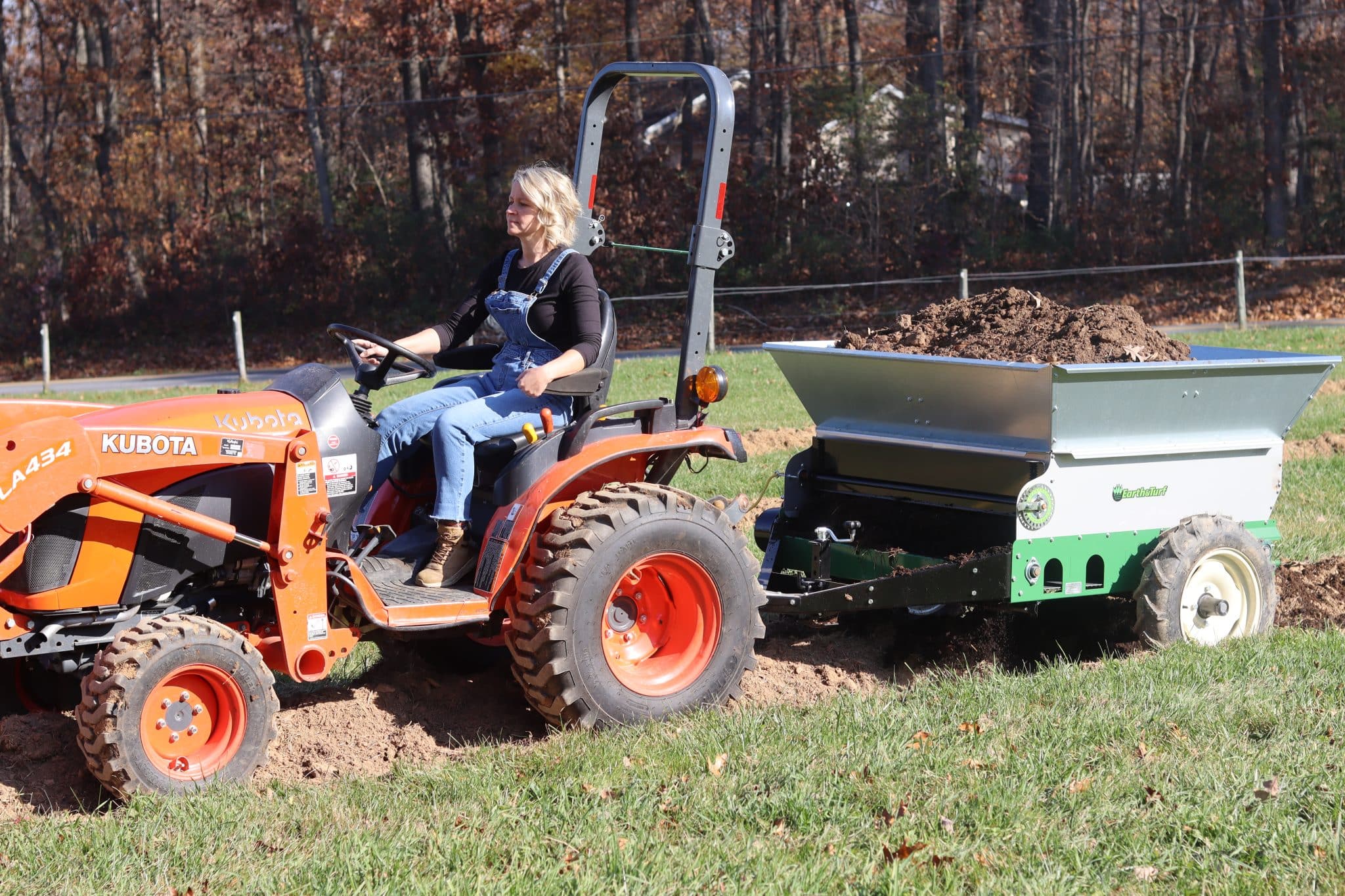 lady driving tractor bulling 248PT topdresser in her garden